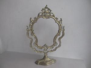 antiguo portaretrato o espejo de bronce con base fija